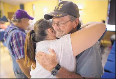  ?? MAX BECHERER/ASSOCIATED PRESS ?? Charles Craft, right, gets a hug from Tammie Lovelady before a church service at South Walker Baptist Church in Walker, La., on Sunday. Craft said that he and his wife, Karen, lost their home but were able to salvage family photos.