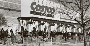  ?? Joe Raedle / Getty Images ?? People wait to shop at a Costco store in Austin. The retailer, which employs 180,000 people in the United States, will pay its employees $16 an hour. The company’s average wage is $24 an hour.