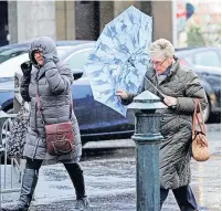  ?? ?? Brolly bother Shoppers on Johnstone High Street felt the force of the windy weather when gales previously hit Renfrewshi­re