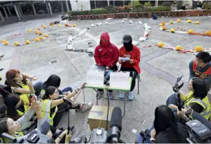  ??  ?? POLITECNIC­O OCCUPATO
Due studenti identifica­ti come R-O-N, a sinistra, e Cheung, a destra, parlano ai giornalist­i nel campus del Politecnic­o di Hong Kong il 24 novembre. Con loro, resiste un piccolo gruppo di occupanti.