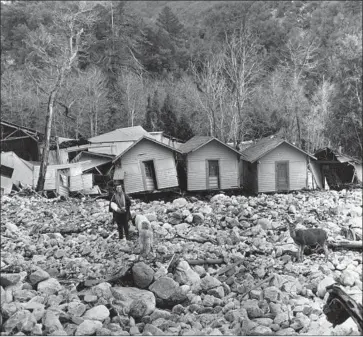  ?? Los Angeles Times ?? RUTH CURRY, owner of Camp Baldy resort, stands in front of cabins damaged by f looding caused by six days of storms in 1938. This photo was originally published in the March 7, 1938, edition of the Los Angeles Times.