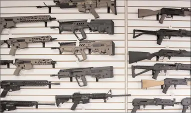  ?? The Canadian Press ?? In this file photo, semi-automatic rifles fill a wall at a gun shop in Lynnwood, Wash. Canada’s federal government is poised to ban a variety of assault-style rifles.