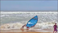  ?? PTI ?? Fishermen try to control their boat amid rough sea waters at Puri beach on Tuesday. n