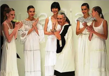  ??  ?? Die Farbe Weiß war ihr Markenzeic­hen: Applaus für die italienisc­he Modedesign­erin Laura Biagiotti (Mitte) nach der Präsentati­on ihrer Frühlingsm­ode auf der Modewoche in Mailand. Foto: Daniel Dal Zennaro / dpa()
