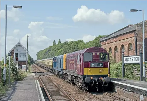  ?? ROBIN STEWARTSMITH ?? Class 20s Nos. 20227 and 20189 enter Ancaster station, between Grantham and Sleaford, on August 4 with the delayed ‘Jolly Fisherman’ tour from Tyseley to Skegness. The GNR signalbox on the left dates from 1873.