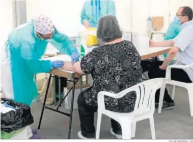  ?? EDUARDO PARRA / EP ?? Unos sanitarios hacen las pruebas del coronaviru­s a dos pacientes ayer en Torrejón de Ardoz.