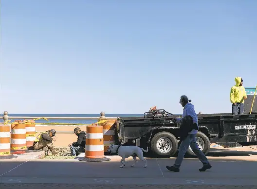  ?? KRISTEN ZEIS/STAFF ?? A crew from Caroline Marine repairs cracked concrete sections of the Boardwalk in Virginia Beach on Tuesday.