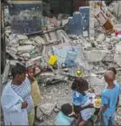  ?? Joseph Odelyn/Associated Press ?? A family eats breakfast in front of homes destroyed by a 7.2 magnitude earthquake in Les Cayes, Haiti, on Sunday.