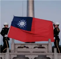  ?? AFP PHOTO ?? FLAG OF THEIR FATHERS
Guards raise Taiwan’s flag on Democracy Boulevard at the Chiang Kai-shek Memorial Hall in the capital Taipei on Jan. 14, 2024.