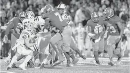  ?? JENNIFER LETT/SUN SENTINEL ?? Jesuit running back Nick Spurlin (15) and Cardinal Gibbons defender Khris Bogle (7) battle it out in during the state semifinal game in Fort Lauderdale on Friday night.