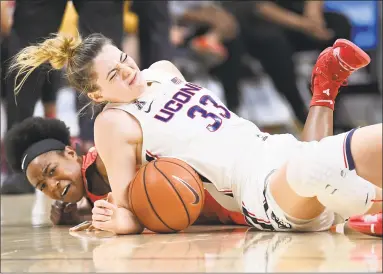  ?? Jessica Hill / Associated Press ?? UConn’s Katie Lou Samuelson, top, and Houston’s Julia Blackshell-Fair fall to the court chasing a loose ball during the first half on March 2 in Storrs. Samuelson left the game injured after the play.