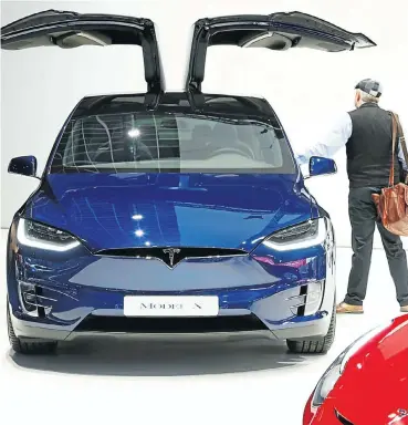  ?? Picture: Reuters/Francois Lenoir ?? A visitor inspects a Tesla Model X electric vehicle at the Brussels Motor Show, Belgium, on Friday.