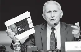  ?? GREG NASH/POOL VIA GETTY-AFP ?? Dr. Anthony Fauci shows a screen grab of a campaign website while answering questions from Sen. Rand Paul during a contentiou­s exchange on Tuesday.