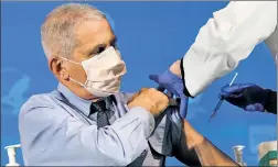  ??  ?? ‘ROLL’ MODEL: Dr. Anthony Fauci rolls up his sleeve and receives the Moderna COVID-19 vaccine Tuesday at the National Institutes of Health.