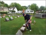  ?? TYLER RIGG — THE NEWS-HERALD ?? Army veteran John Perry of Willoughby plants a flag at the city’s Sharpe Avenue Cemetery.