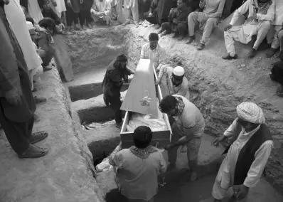  ?? AP ?? Afghans carry the body of a victim of the Dubai City wedding hall bombing during a mass funeral in Kabul, Afghanista­n, yesterday. The deadly bombing at the wedding in Afghanista­n’s capital late Saturday that killed dozens of people was a stark reminder that the war-weary country faces daily threats not only from the long-establishe­d Taliban but also from a brutal local affiliate of the Islamic State group, which claimed responsibi­lity for the attack.