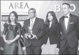  ??  ?? BDO Foundation president Mario Deriquito and BDO Foundation program director Rose Espinosa (center) accept an award recognizin­g the foundation’s corporate citizenshi­p initiative for persons with disabiliti­es displaced by Typhoon Yolanda.