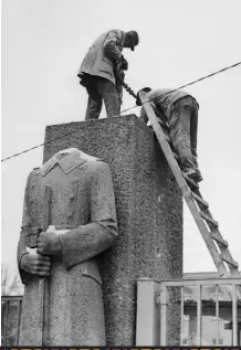  ??  ?? Shown here shortly after World War II with Allied workers,
a statue of a Nazi soldier that
once stood in Berlin. The statue was destroyed as part of the nation’s official de-Nazificati­on
program.
The Judensau sculpture on the wall of the Wittenberg church.
“Rabini,” a nonsense word,
was intended to further mock the rabbi shown peering at the
pig’s anus.