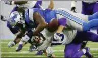  ?? RICK OSENTOSKI — THE ASSOCIATED PRESS ?? Vikings wide receiver Adam Thielen (19) loses control of the ball after a hit by Lions defensive end Devin Taylor during the first half of an NFL football game, Thursday in Detroit.