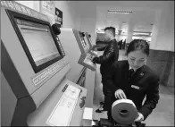  ?? WU JIBIN / XINHUA ?? A railway worker maintains a self-service ticket vending machine at Kaili Railway Station in Guizhou province on Tuesday.