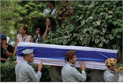  ?? (AP/Maya Alleruzzo) ?? Israeli soldiers carry the flag-covered coffin of Col. Roi Levy during his funeral Monday at the Mount Herzl cemetery in Jerusalem. Levy was killed after Hamas militants stormed from the Gaza Strip into nearby Israeli towns.