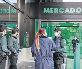  ??  ?? Guardia Civil outside a supermarke­t to ensure the rules regarding shopping are obeyed