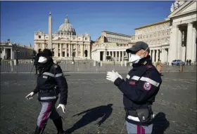  ?? ANDREW MEDICHINI — THE ASSOCIATED PRESS ?? Police officers wearing masks patrol an empty St. Peter’s Square at the Vatican on Wednesday. Pope Francis held his weekly general audience in the privacy of his library as the Vatican implemente­d Italy’s drastic coronaviru­s lockdown measures, barring the general public from St. Peter’s Square and taking precaution­s to limit the spread of infections in the tiny city state.