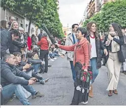  ?? ?? Venta ambulante de sillas portátiles en una calle por la que pasan cofradías.