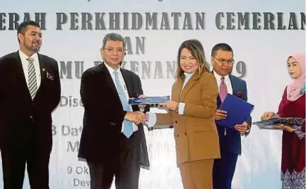  ?? (Foto Mohd Fadli Hamzah /BH) ?? Saifuddin menyampaik­an anugerah kepada kakitangan awam pada majlis Anugerah Perkhidmat­an Cemerlang 2018 dan Jasamu Dikenang 2019 di Putrajaya, semalam.