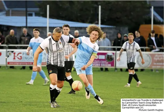  ?? Picture: Gareth Hughes ?? Ammanford’s Lee Trundle is challenged by Carmarthen Town’s Greg Walters in their JD Cymru South encounter. Carmarthen won 3-1.