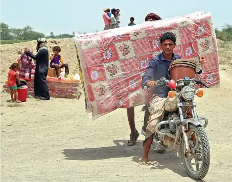  ?? AFP ?? Yemenis receive shelter aids, tents, mattresses and blankets from an aid group after their straw camp was exposed to a fire in the Khokha district of Hodeidah.