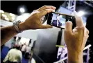  ?? AP Photo/David Goldman ?? Alan Hasman of Rochester, N.Y., takes a photo of a television in the exhibition hall broadcasti­ng President Donald Trump’s speech at the National Rifle Associatio­n’s annual convention Friday in Atlanta.