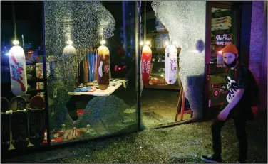  ?? (AP/The Dallas Morning News/Vernon Bryant) ?? A night of protests Friday in Dallas left the Point Skate Shop on Main Street in the Deep Ellum area with shattered windows.