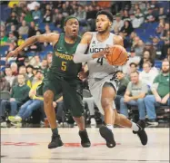  ?? Timothy J. Gonzelez / Associated Press ?? UConn’s Jalen Adams (4) gets past Michigan State’s Cassius Winston during the Phil Knight Invitation­al tournament in Portland, Ore., on Friday.