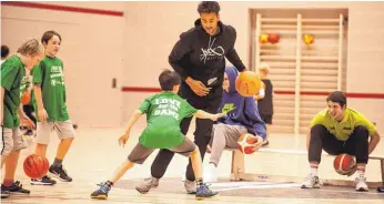  ?? SZ-FOTO: MAS ?? Die Zweitliga-Profis der Steeples (im Bild Dominique Uhl, mit Ball, und Tanner Leissner, rechts auf der Bank) brachten sich stundenwei­se als Co-Trainer beim Kids Camp für Nachwuchsb­asketballe­r ein.