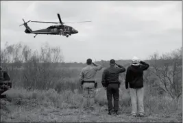  ?? ASSOCIATED PRESS ?? PRESIDENT DONALD TRUMP SALUTES AS A U.S. CUSTOMS and Border Protection helicopter passes as he tours the U.S. border with Mexico at the Rio Grande on Thursday in McAllen, Texas.