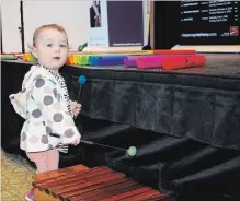  ?? ALLAN BENNER THE ST. CATHARINES STANDARD ?? One-year-old Ruth Biss discovers she may have a talent for the xylophone during a Niagara Symphony Orchestra instrument petting zoo at the Pen Centre, Saturday.