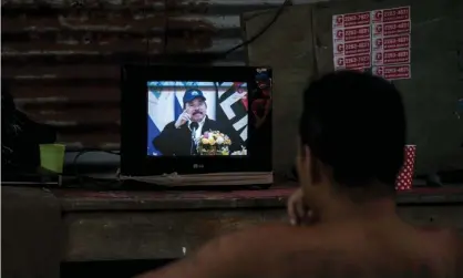  ??  ?? A man watches a television as President Daniel Ortega appears during a broadcast in Managua, Nicaragua, on Wednesday. He boasted that Nicaraguan­s ‘haven’t stopped working’. Photograph: Jorge Torres/EPA