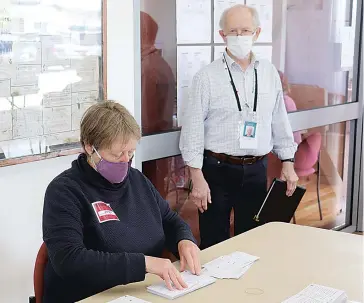  ??  ?? VEC election manager Phillip Robinson watches as counting officer Andrea Collins separates vote declaratio­ns from envelopes as the vote counting process gets underway in Warragul yesterday.