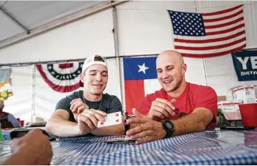  ?? Jon Shapley / Houston Chronicle ?? Chuck Swisher, a bull fighter, right, and Riker Carter, a bull rider, play a game they call “Webster,” after eating at the Rodeo Village.