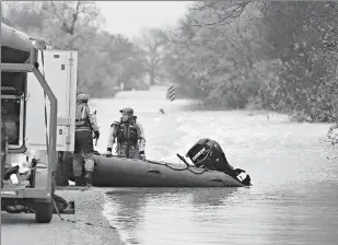  ?? Vernon Bryant/The Dallas Morning News via Associated Press ?? Dallas Fire Department members prepare to put their boat away after rescuing a driver whose vehicle was swept away by floodwater­s Saturday in Seagoville, Texas.