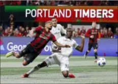  ?? TODD KIRKLAND — THE ASSOCIATED PRESS ?? Atlanta United forward Josef Martinez, left, and Portland defender Larrys Mabiala fight for the ball during the MLS Cup final Saturday night, a 2-0 win for Atlanta.