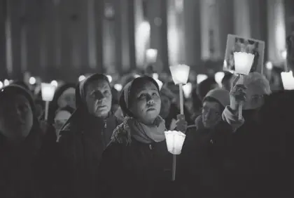  ?? OLI SCARFF/GETTY IMAGES ?? Pilgrims and clergy members hold a candleligh­t vigil in Saint Peter’s Square while facing Pope Benedict’s private apartment Wednesday after he gave a personal farewell address. The first pope to retire since 1415, Benedict plans to spend the rest of his life in solitude.