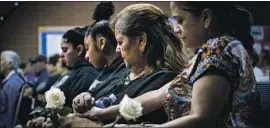  ??  ?? IRENE GARCIA and Lisa Garcia, right, hold hands during a prayer for people killed by law officers. Irene’s grandson was fatally shot by a deputy June 27.