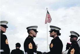  ?? [AP PHOTO] ?? U.S. Marine Corps soldiers stand beneath the U.S. flag Sunday during a Memorial Day commemorat­ion at the Aisne-Marne American Cemetery in Belleau, France.