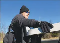  ?? BARBARA HADDOCK TAYLOR/BALTIMORE SUN ?? Brian Thompson is bundled up as he rides on the back of a golf cart on the way to a tee box in the Jack Frost tournament at Pine Ridge Golf Course in February.