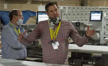  ?? Christian Snyder/Post-Gazette ?? David Voye, left, and Chet Harhut, right, the manager and deputy manager of the Allegheny County Elections Division, respective­ly, explain the ballot-counting process at the Allegheny County elections warehouse on the North Side before the June primary.