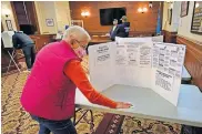  ?? [ROBERT F. BUKATY/ THE ASSOCIATED PRESS] ?? Susan Turcotte, assistant city clerk, disinfects a table after it was used by a resident to fill out an absentee ballot during early voting Friday in Lewiston, Maine.