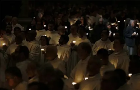  ?? Gregorio Borgia/Associated Press ?? Priests hold candles as they wait for the arrival of Pope Francis for the celebratio­n of the world day of consecrate­d life Feb. 2 in St. Peter’s Basilica at the Vatican.