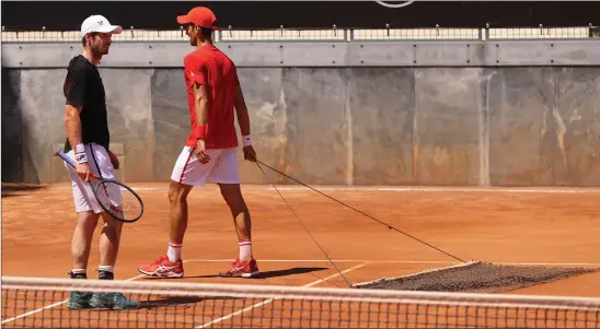  ??  ?? Andy Murray watches on as Novak Djokovic tends to the clay surface during their practice session in Rome yesterday